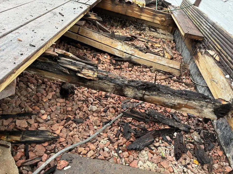 Close-up of rotten joists and rubble found beneath the old decking