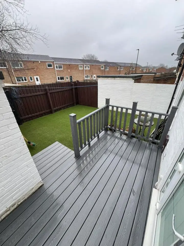The finished composite deck with artificial grass beyond