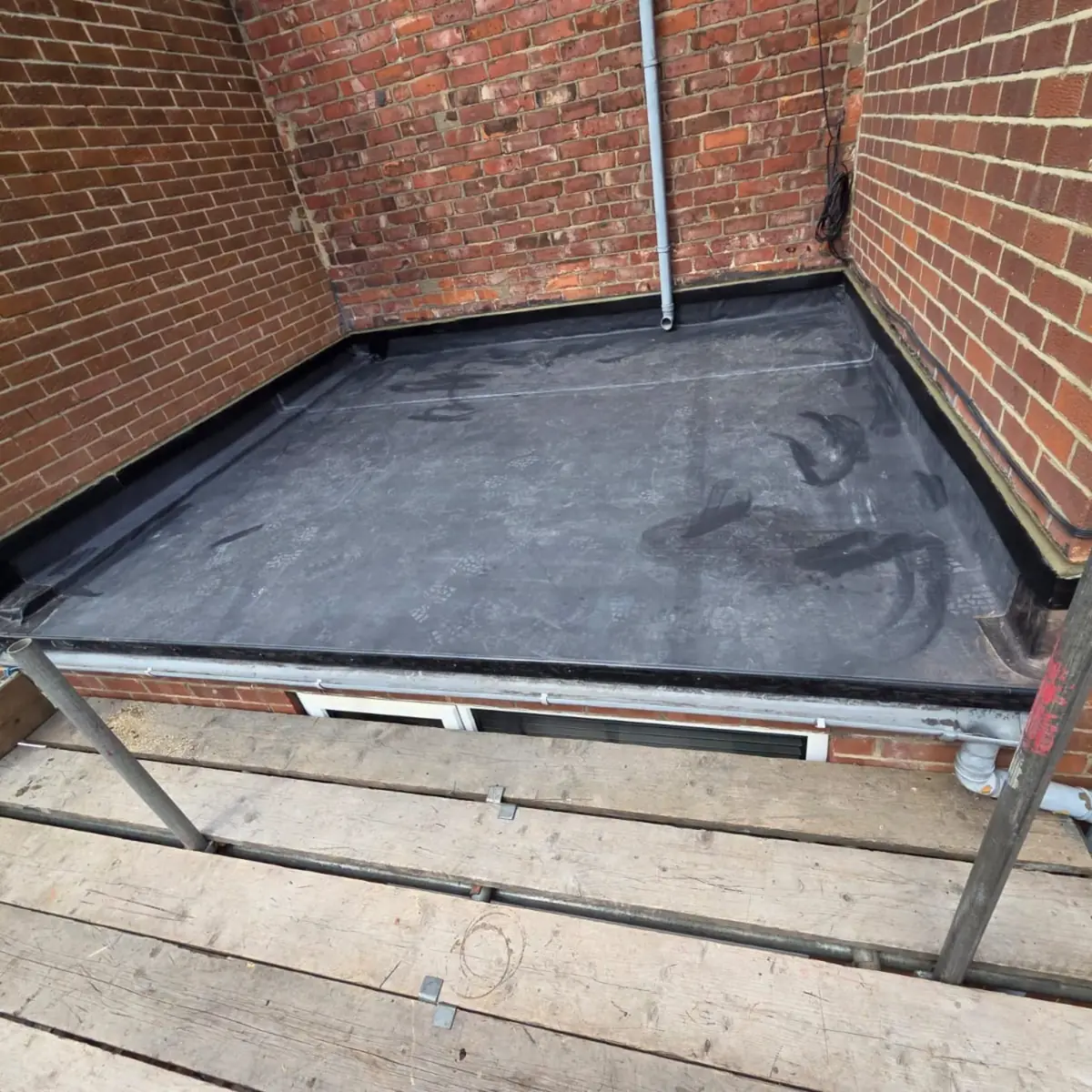 The same roof recovered in EPDM rubber, draining cleanly with dressed upstands