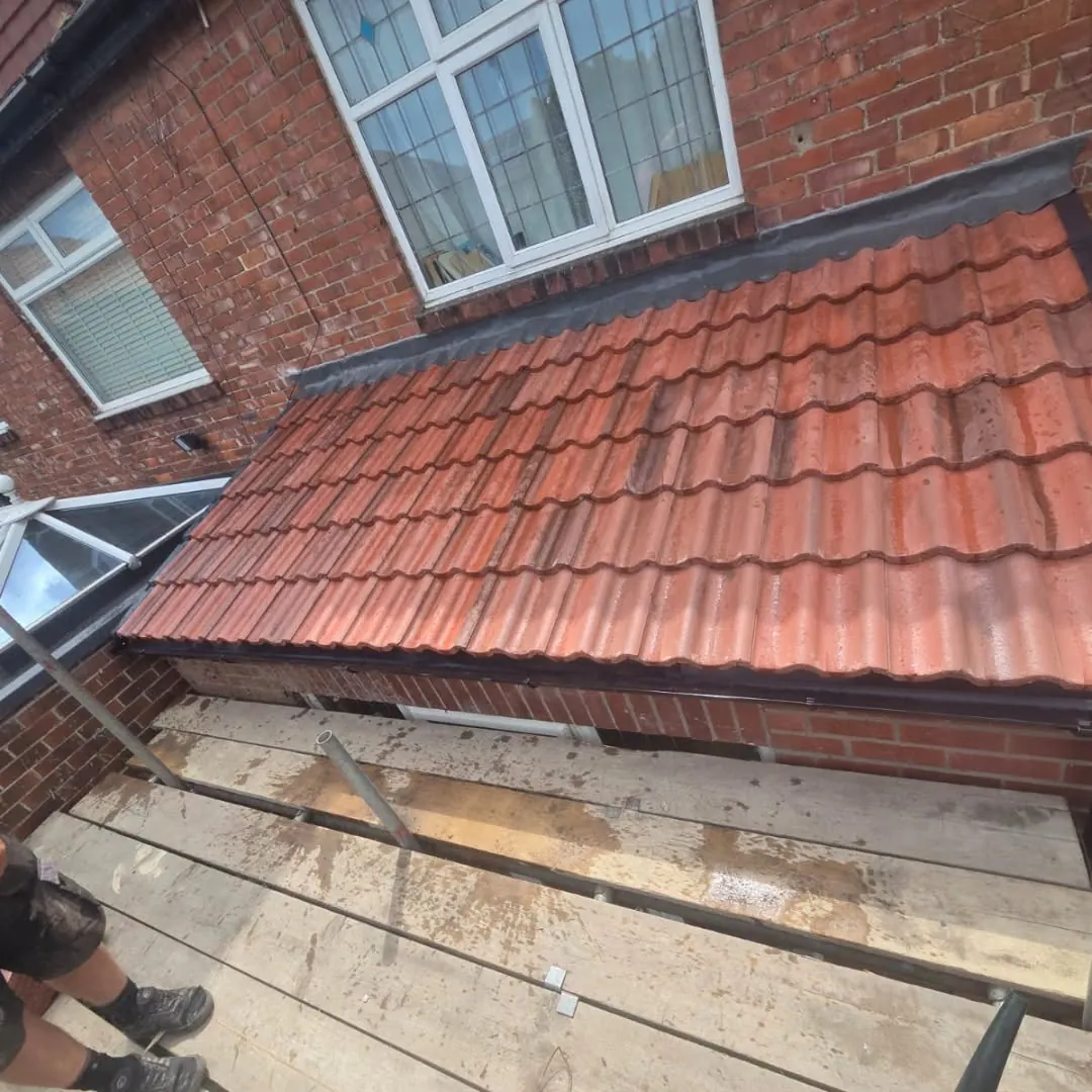 The finished roof with correctly rated tiles, dry verge and new black guttering