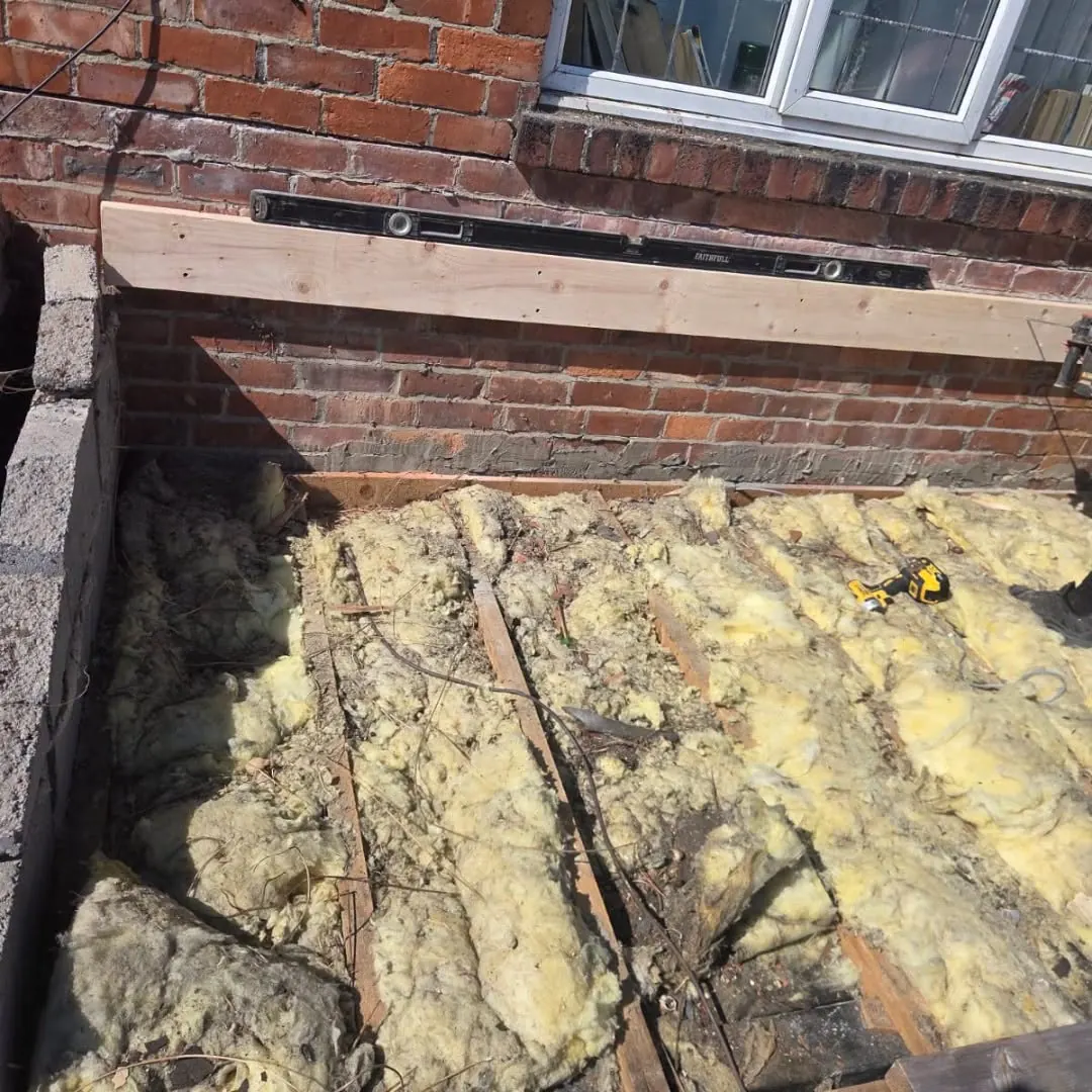 A roof stripped back revealing poorly fixed timbers beneath the covering