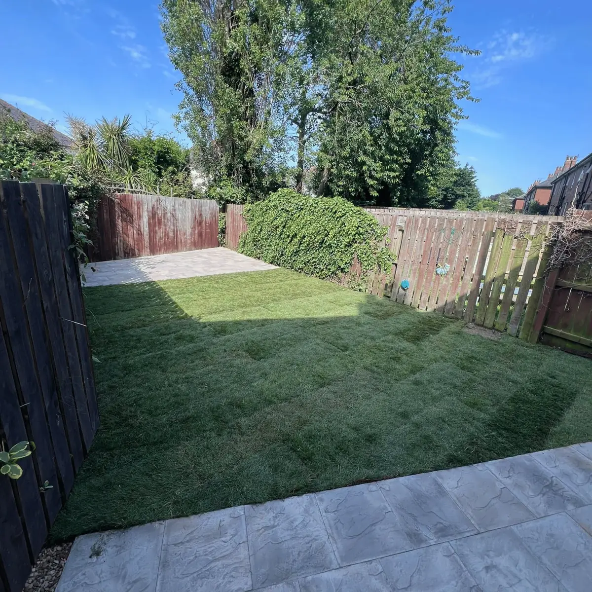 The finished garden with a new lawn and patio, cleared of overgrowth