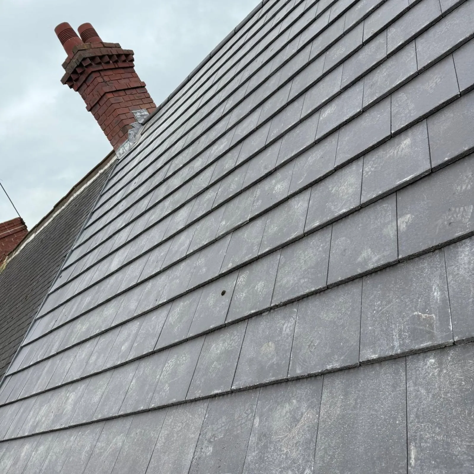 Lead flashing dressed in where a slate roof meets a chimney stack