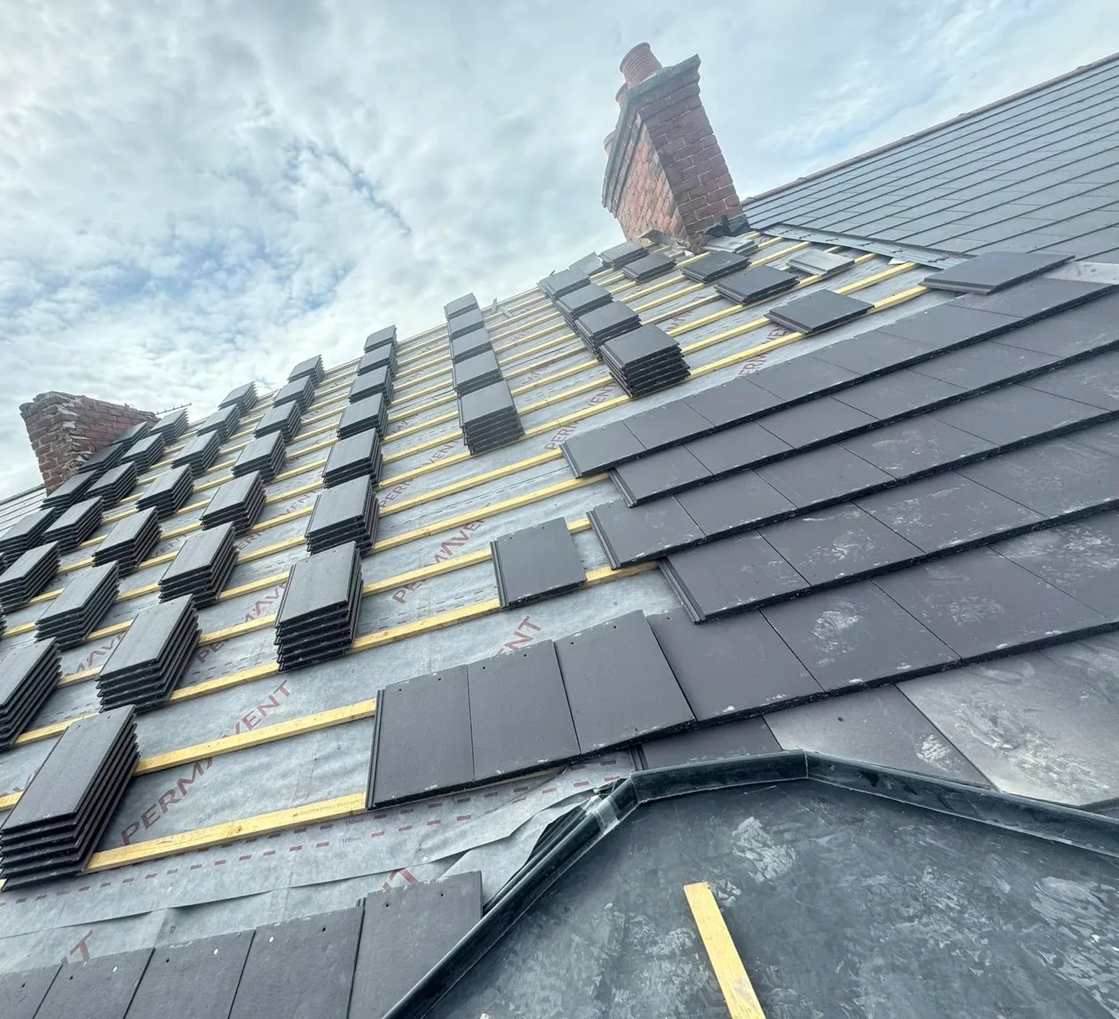A roof being re-slated over new breathable membrane and treated battens
